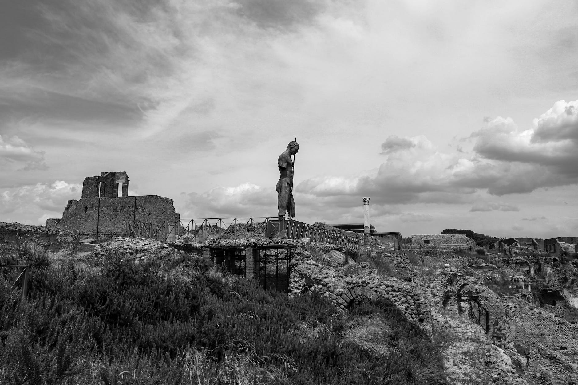 grayscale photo of monumental sculpture on top of ruins